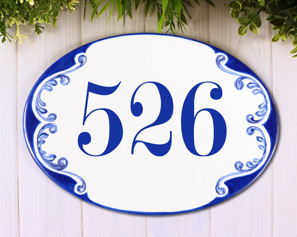 blue house number sign hand painted on oval ceramic plaque, blue motive on the sides