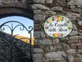 Ceramic House name sign with yellow and pink roses on a stone wall