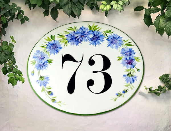 Oval ceramic house number plaque hand painted with blue cornflower and green border, custom address sign for outdoor