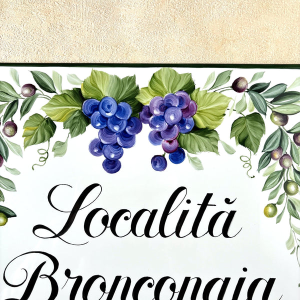 Decorative design with grapes and leaves on ceramic tile with 'Localitá Bronconaia' text.