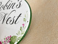 close-up of a ceramic house sign border hand painted in green color