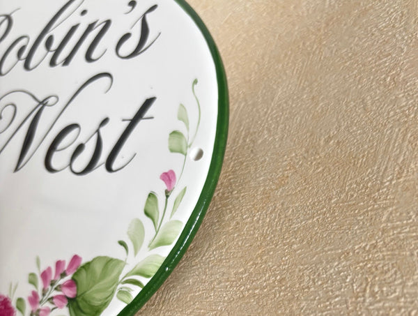 close-up of a ceramic house sign border hand painted in green color