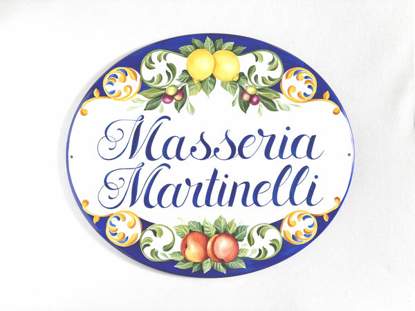 oval ceramic house plaque hand-painted with lemons, peaches, olives on blue background, personalized with name.
