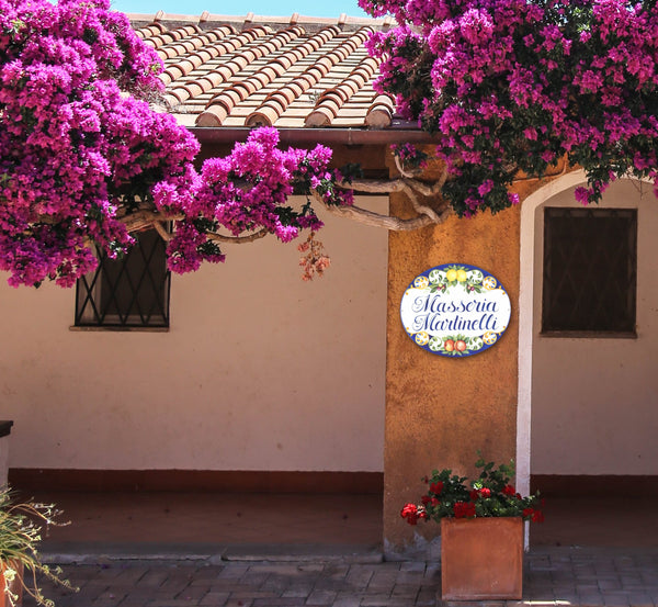 ceramic house name sign hand-painted in italian style, mounted on a mediterranean front door