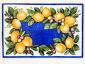 Hand painted decorative tile mural with lemons and olives on a deep blue background, mounted on an outdoor wall. Mediterranean-style ceramic wall decor.