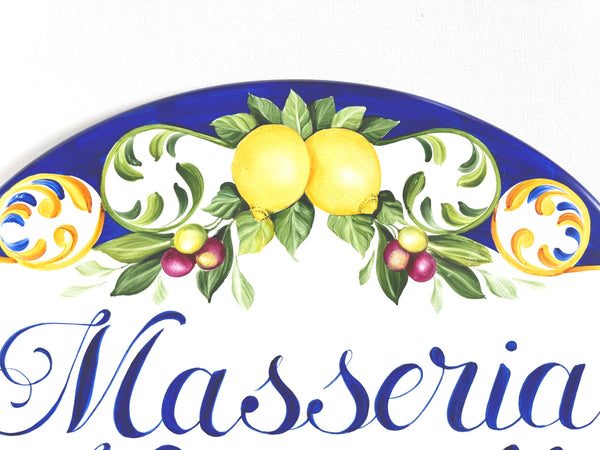 Close-up of a ceramic house plaque hand-painted  with lemons  and olives
