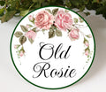 Round ceramic plaque hand-painted with pink roses and green leaves with the text Old Rosie