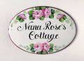 oval ceramic name sign hand-painted with pink roses and green leaves