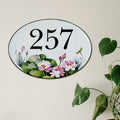 Decorative ceramic house number sign hand-painted with floral design on a light background