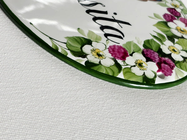 detail of oval ceramic sign border hand-painted with blackberries 