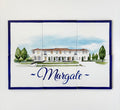 A rectangular ceramic tile plaque featuring a hand-painted illustration of a white mansion with green trees and the word 'Margate' in blue script, mounted on a white wall.