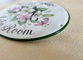 close-up of a ceramic plaque hand-painted in green color with lily