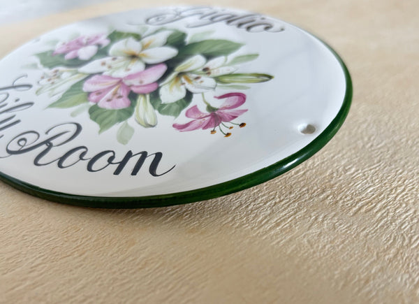 close-up of a ceramic plaque hand-painted in green color with lily