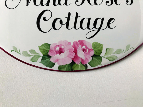 edge detail of an oval ceramic house sign hand-painted with roses