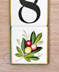 detail of a hand painted ceramic tile with olive branch