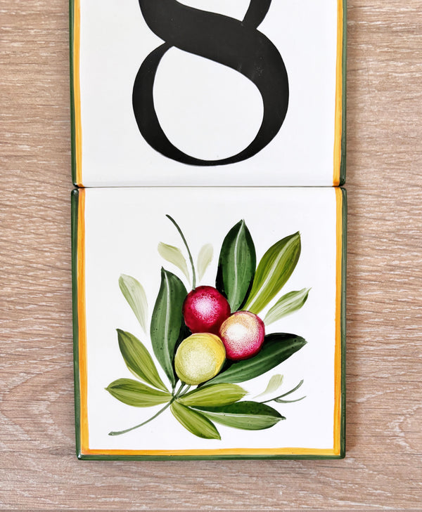 detail of a hand painted ceramic tile with olive branch