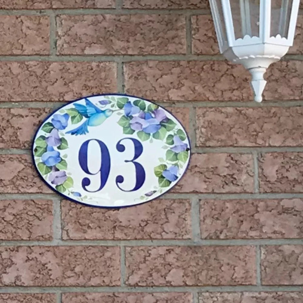 Oval house number plaque hand painted with blue flowers and a blue hummingbird 