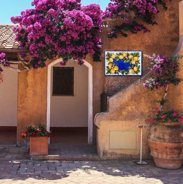 Decorative entrance to a building with flowers and a tile mural.