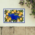 Decorative wall tile mural with lemon and olive mounted on white wall
