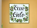 A square tile mural hand-painted with olive branches and the text "Can Cielo", yellow and green border