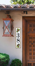 A vertical rectangular ceramic tile sign with the numbers 38 in black and hand painted olive branch 