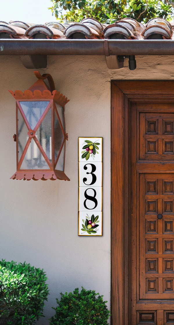 A vertical rectangular ceramic tile sign with the numbers 38 in black and hand painted olive branch 