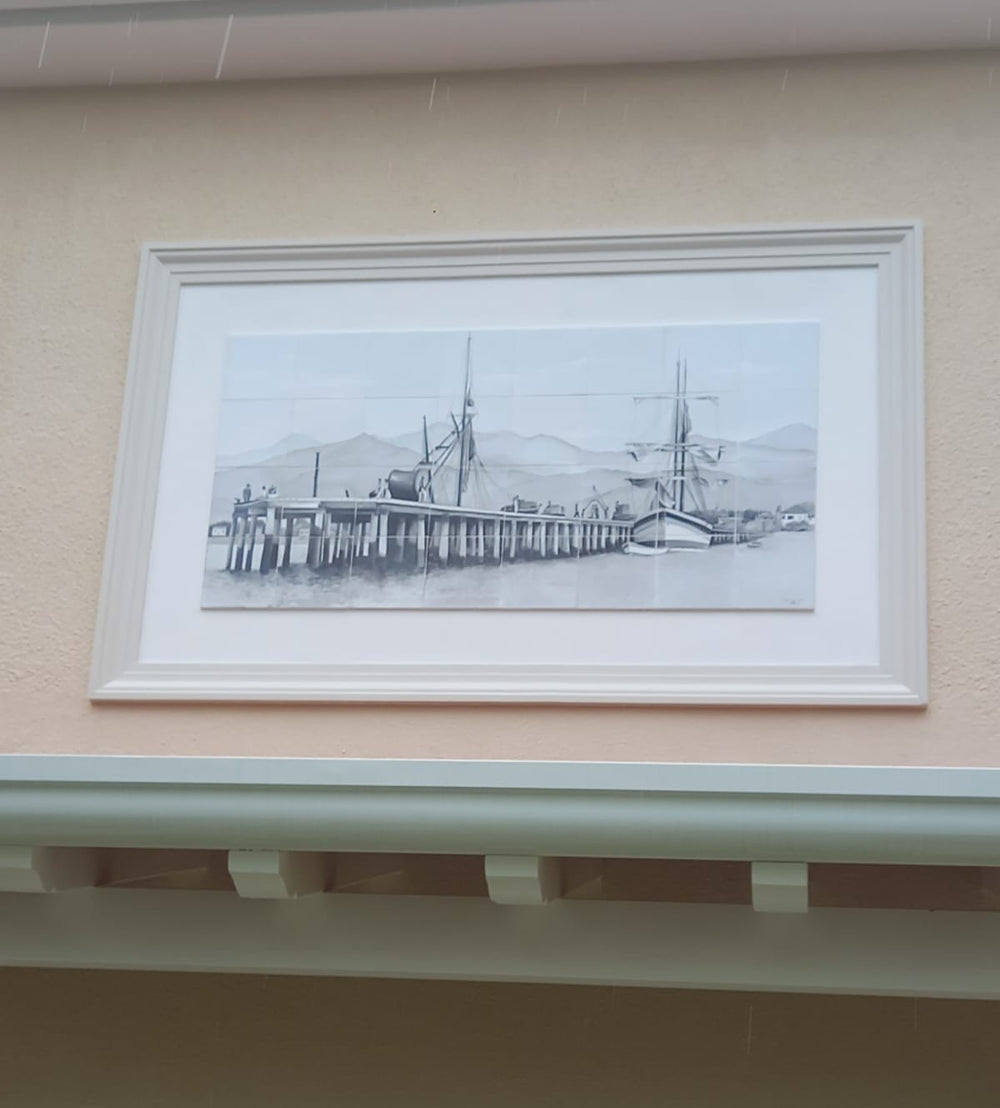 Hand-painted tile mural depicting a dock and a sailing ships, installed on an exterior wall