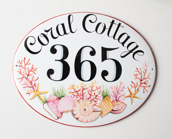 ceramic house number plaque hand painted with pink corals and shells. the house number is painted in center i black color and the name is on the top.
