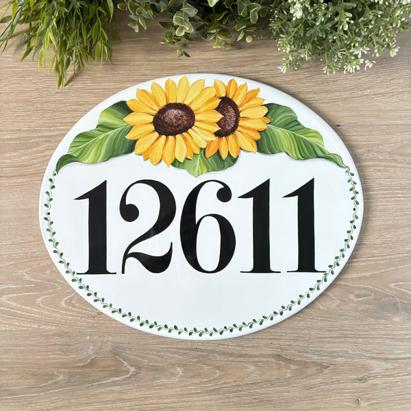 oval ceramic house number sign hand-painted with sunflowers and green eaves