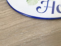 border thickness detail of a ceramic house sign hand painted in blue