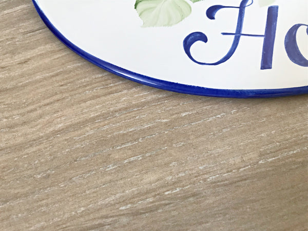 border thickness detail of a ceramic house sign hand painted in blue