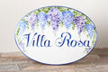 Ceramic oval house plaque hand painted with blue and purple wisteria flowers, personalized with the name painted in blue
