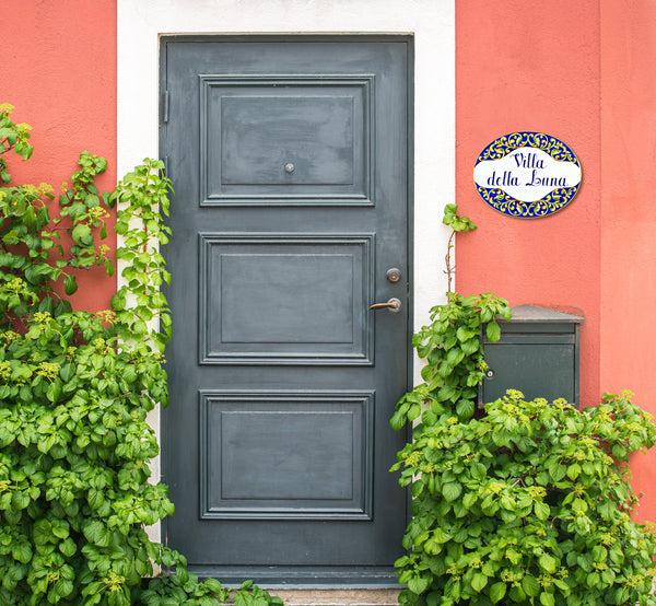 ceramic house sign for outdoor hand-painted spanish revival motifs, mounted on a front door