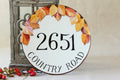 round house number sign with fall leaves