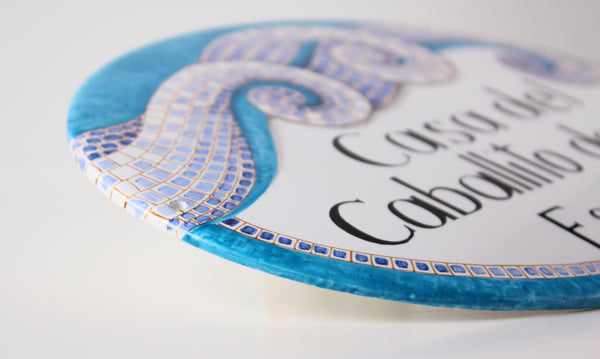 detail of border of a ceramic house sign hand-painted in mosaic style, teal color
