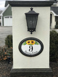 ceramic house number plaque with sunflowers on a pillar