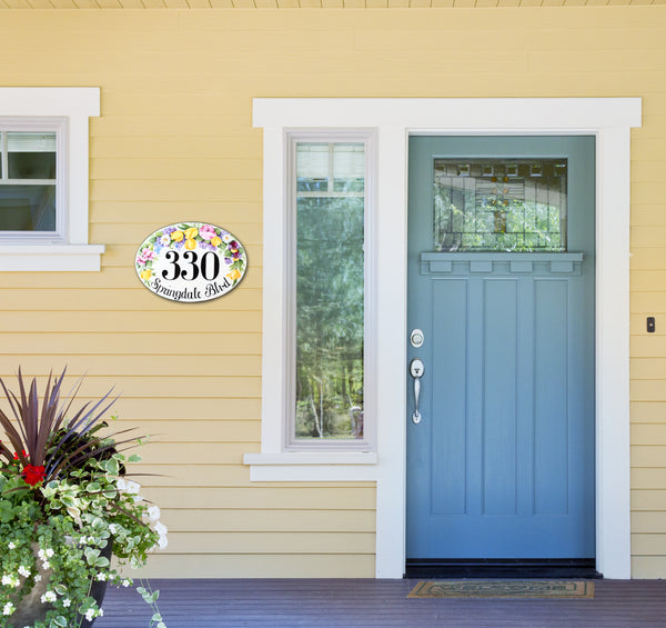 oval ceramic house number hand-painted with tulips, pansies, roses and lilacs, mounted on a front door