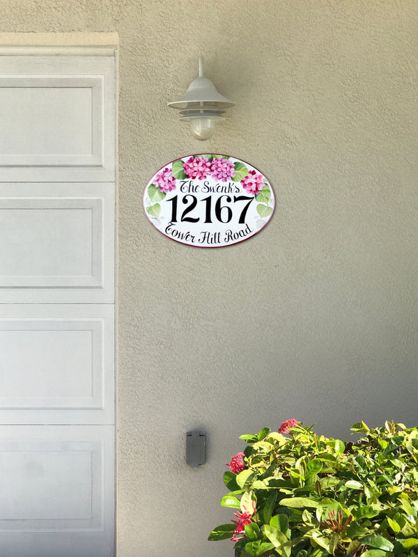 ceramic house number sign hand-painted with pink hydrangea mounted on a wall