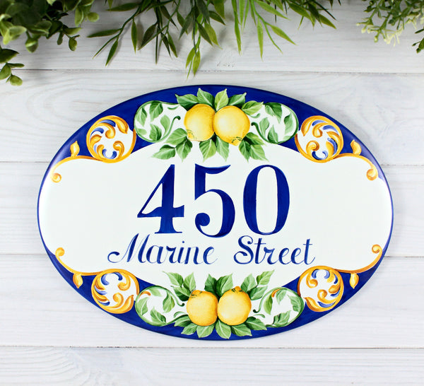 ceramic house number hand -painted with lemon and green leaves on a blue background
