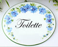 ceramic oval plaque hand painted with cornflowers with text "Toilette"