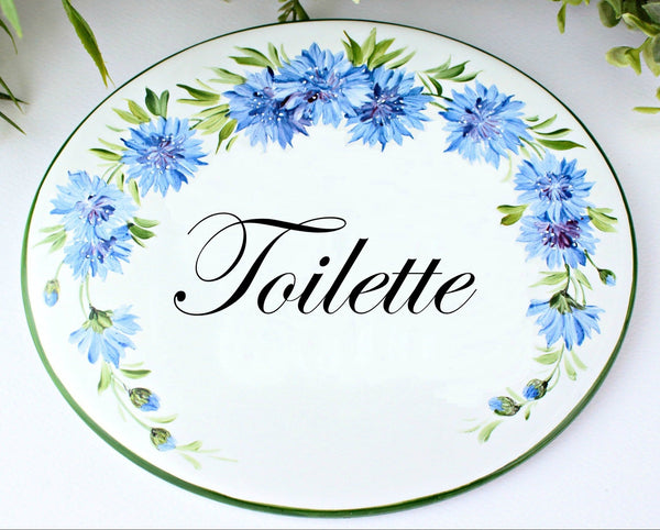 ceramic oval plaque hand painted with cornflowers with text "Toilette"